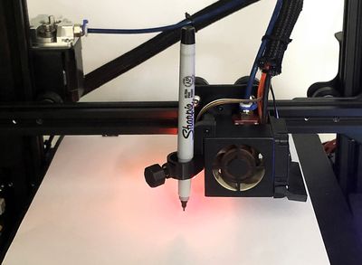 Picture of a 3d printer with a pen attached to the extruder head